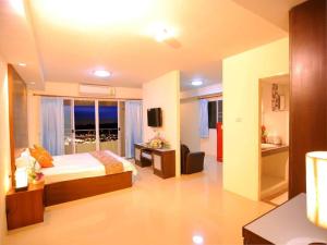 een hotelkamer met een bed en een televisie bij Grand Living Residence in Chiang Mai