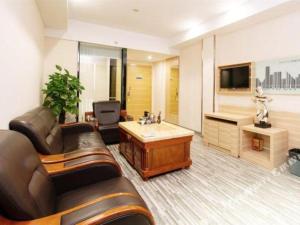 a living room with a leather couch and a television at City Comfort Inn Yunfu Luoding Triumph Plaza in Shuangdongjieban