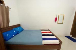 a small bedroom with a bed with a blue bedspread at OYO 93784 Kost Bu Eli Syariah in Malang