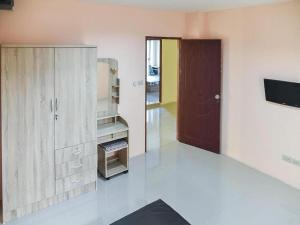 a room with a kitchen with a cabinet and a television at Orchid Residence At Amata in Si Racha