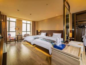 a hotel room with two beds and a mirror at Zmax Hotel Guangzhou Railway Station in Guangzhou +223 photos