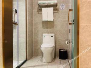 a bathroom with a toilet and a glass shower at GreenTree Inn Express Qingdao Laixi High-Speed Railway Station Shenzhen Road in Laixi +153 photos