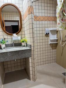 une salle de bain avec un lavabo et un miroir dans l'établissement Buffalo Bill Hotel Koh Chang, à Ko Chang