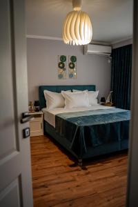 Un dormitorio con una cama y una lámpara de araña. en Apartament Marlen, en Mangalia