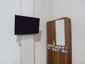 a tv hanging on a wall next to a door at OYO 92403 Gatsu Homestay in Medan