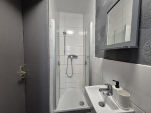 a white bathroom with a shower and a sink at Mikra Homes24 in Gößnitz in Gößnitz