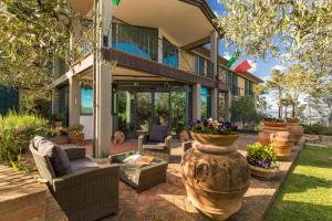 ein Haus mit einer Terrasse mit Stühlen und Blumen in der Unterkunft Villa Cesi Resort & Spa in Impruneta