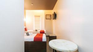 a small room with two beds and a table at RedDoorz @ Express Inn Lapu Lapu in Gun-ob