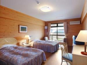 a hotel room with two beds and a window at Hotel Bellreef Otsuki in Otsuki
