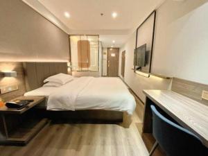 a hotel room with a large bed and a desk at 7 Days Inn Xiangtan Erqiao Fenghuang East Road 1st County High School in Xiangtan