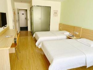 a hotel room with two beds and a television at 7 Days Inn Xiangtan Erqiao Fenghuang East Road 1st County High School in Yisuhe +77 photos