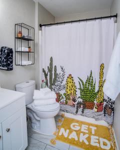 a bathroom with a toilet with a cacti shower curtain at Coffee Bar | Fast Wifi | 5 miles to Schlitterbahn in Schumannsville