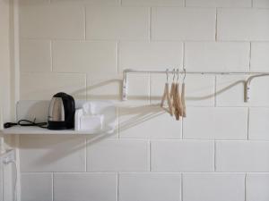 a kitchen with a white tiled wall with a shelf at 78's Hometel Pattaya 101 in Pattaya Central +18 photos