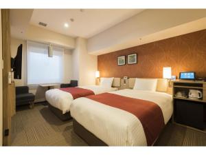 a hotel room with two beds and a television at KEIKYU EX INN Keikyu Kawasaki-Station in Kawasaki +150 photos