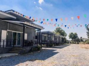 Ein Gebäude, an dem ein Haufen Flaggen hängen. in der Unterkunft Capital O 75412 V Resort in Ban Wang Ton + 34 Fotos