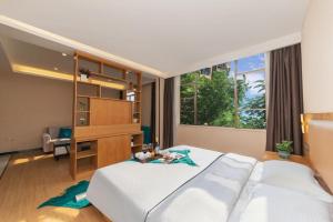 a bedroom with a bed and a desk and a large window at GreenTree Inn Huangshi Huahu Development Zone Daquan Road in Huangshi +267 photos