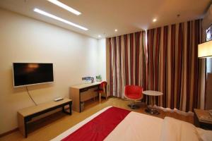 a hotel room with a desk and a television at Thank Inn Hotel Ningxia Yinchuan Xixia District Tongxin Road in Yinchuan