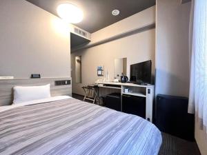 a hotel room with a bed and a desk at Hotel Route Inn Kitamatsudo Ekimae in Kashiwa