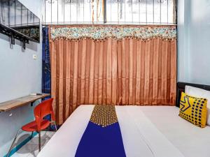 a bedroom with a bed and a orange curtain at SPOT ON 90147 Gosepa Ambengan Plaza in Surabaya +75 photos