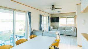 un salon avec un canapé et une table dans l'établissement THE TRAILERHOUSE VILLAGE AMAKUSA MARINA, à Nobotate 142 autres photos