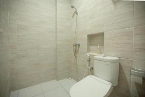 un baño con inodoro y ducha en My Stay Semarang, en Semarang 76 fotos más