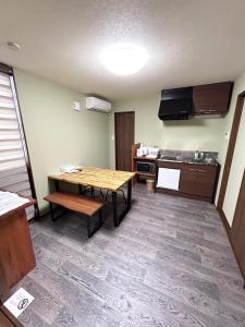 ein kleines Zimmer mit einem Tisch und einer Küche in der Unterkunft ゲストハウス長浜 in Nagahama