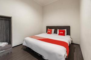 a bedroom with a large bed with red pillows at Hotel O Bidara Guest House Syariah in Mojokerto +15 photos