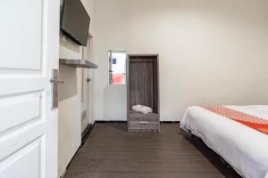 a hotel room with a bed and a mirror at Hotel O Bidara Guest House Syariah in Mojokerto