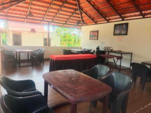 a restaurant with chairs and a table and a bar at Tigerwoods Cottage in Chikmagalūr