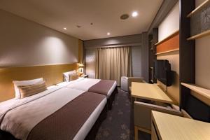 a hotel room with two beds and a flat screen tv at Nagoya Sakae Tokyu REI Hotel in Nagoya