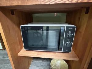 a microwave oven sitting on a wooden shelf at ゲストハウス長浜 グループ旅行や家族旅行カップルでのご利用におすすめです in Nagahama +25 photos