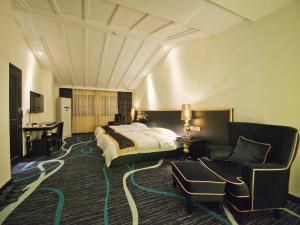 une chambre d'hôtel avec un lit, un bureau et une chaise dans l'établissement Guilin Sapphire hotel, à Guilin