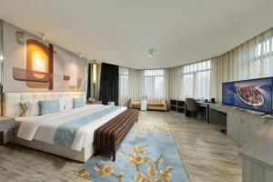 a hotel room with a large bed and a flat screen tv at Jinjiang Metropolo Hotel Shenyang Country Garden Datong Lake Subway Station Branch in Shenyang +167 photos