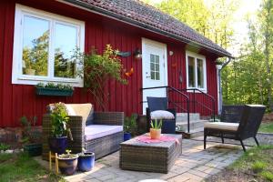 TingsrydVilla Apple Garden的红色的房子,配有椅子和庭院