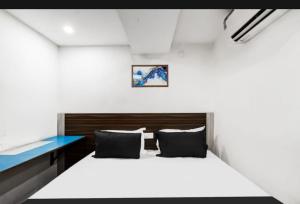 a bedroom with a white bed and a blue desk at Hotel Sun Residency in Hyderabad