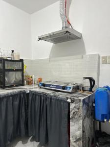 a kitchen with a counter with a stove top at Entire Townhouse - SANTO TOMAS BATANGAS in Santo Tomas +6 photos