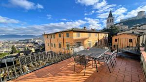 a balcony with a table and chairs on top of a building at 6 guests apt with terrace in pedestrian historic centre of Spoleto in Spoleto