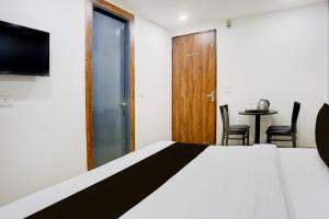Un dormitorio con una cama y una mesa con sillas. en Hotel O Silver Stone, en Nueva Delhi