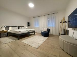 ein Schlafzimmer mit einem Bett und einem Stuhl in einem Zimmer in der Unterkunft HausKaiser in Wulkaprodersdorf
