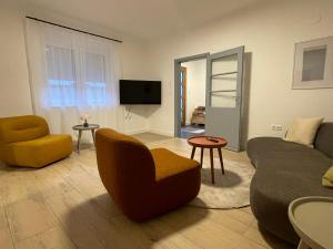 ein Wohnzimmer mit einer Couch und einem Sessel in der Unterkunft HausKaiser in Wulkaprodersdorf