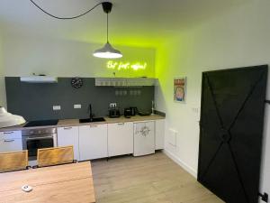 eine Küche mit weißen Schränken und einer schwarzen Tür in der Unterkunft HausKaiser in Wulkaprodersdorf