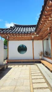 a wooden pergola with a bench on a patio at Wolha in Gyeongju