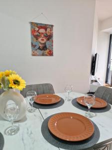 a table with plates and wine glasses on it at Sunflower City Center with free garage in Skopje