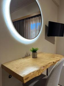 a wooden table with a mirror on a wall at Semiramis in Lefkada