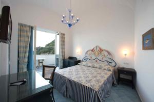 a bedroom with a bed and a chandelier at Palazzo Marzoli charme Resort - Small Luxury Hotel in Positano