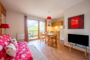a living room with a couch and a dining room at Appartement La Montagne in Orelle
