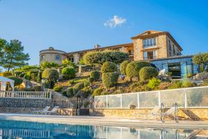a house on top of a hill with a swimming pool at La Bastide De Tourtour Hotel & Spa in Tourtour