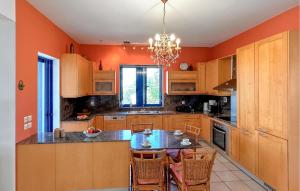 a kitchen with orange walls and a table and chairs at Gorgeous Home In Platanias,Rethymno in Platanes +32 photos