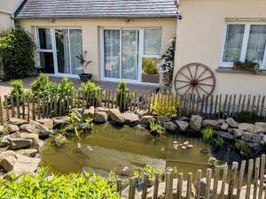 a garden with a pond in front of a house at Chambres d'hôtes chez l'habitant - Bed & Breakfast homestay in Huisnes-sur-Mer