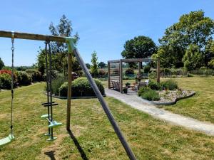 a swing set in a park with a bench at Chambres d'hôtes chez l'habitant - Bed & Breakfast homestay in Huisnes-sur-Mer